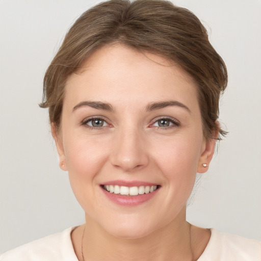 Joyful white young-adult female with short  brown hair and grey eyes