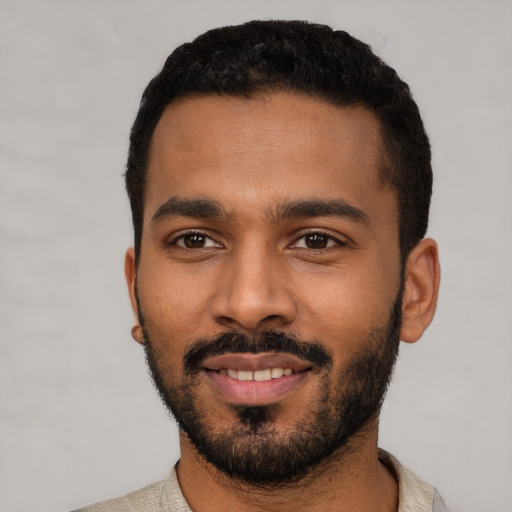 Joyful black young-adult male with short  black hair and brown eyes