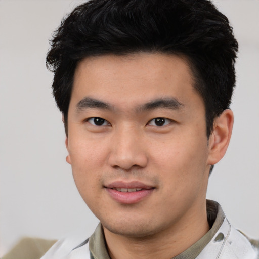 Joyful asian young-adult male with short  black hair and brown eyes