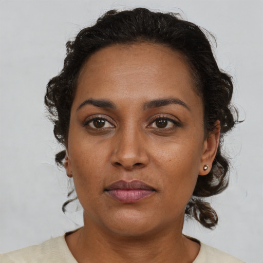 Joyful black young-adult female with medium  brown hair and brown eyes