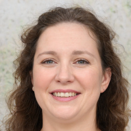 Joyful white adult female with long  brown hair and brown eyes