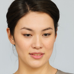 Joyful asian young-adult female with medium  brown hair and brown eyes