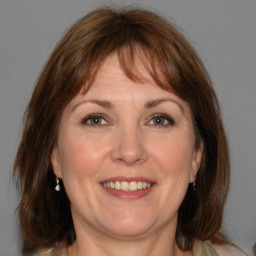 Joyful white adult female with medium  brown hair and blue eyes