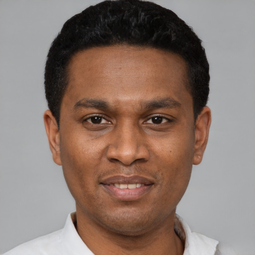 Joyful black young-adult male with short  black hair and brown eyes