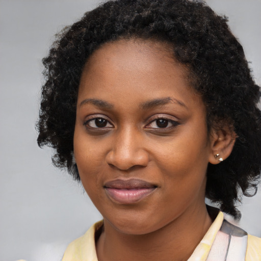 Joyful black young-adult female with long  black hair and brown eyes