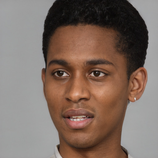 Joyful black young-adult male with short  black hair and brown eyes