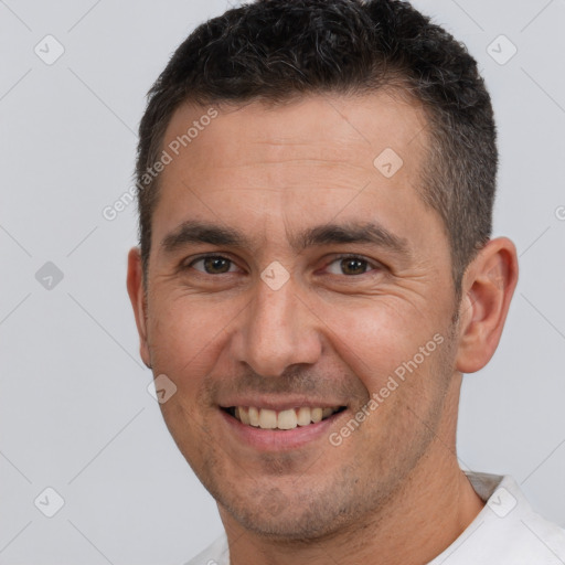 Joyful white adult male with short  brown hair and brown eyes