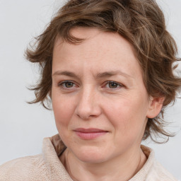 Joyful white adult female with medium  brown hair and blue eyes