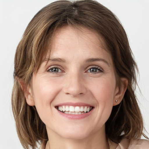 Joyful white young-adult female with medium  brown hair and grey eyes