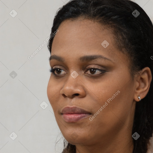 Joyful black young-adult female with long  black hair and brown eyes