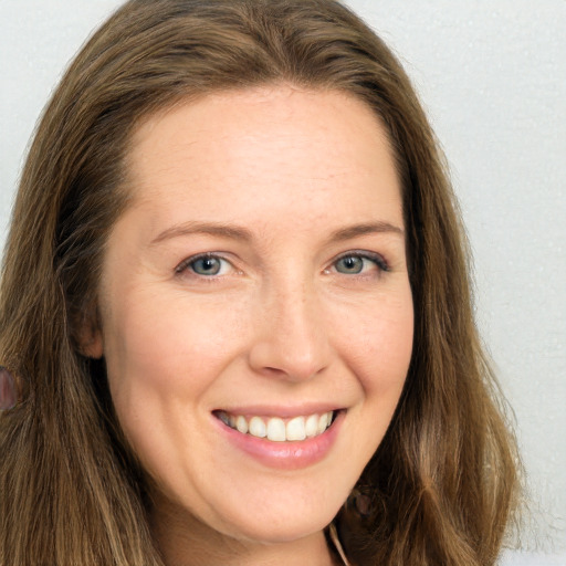 Joyful white young-adult female with long  brown hair and green eyes