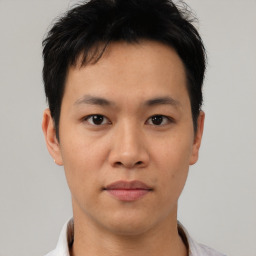 Joyful asian young-adult male with short  black hair and brown eyes