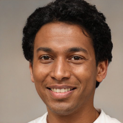 Joyful black young-adult male with short  black hair and brown eyes