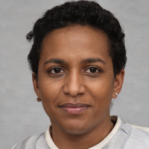 Joyful black young-adult female with short  brown hair and brown eyes