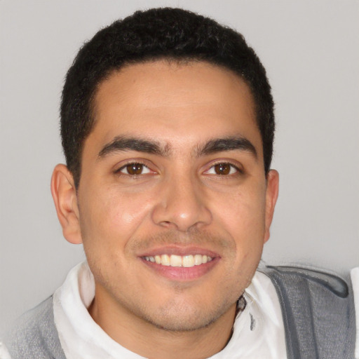 Joyful latino young-adult male with short  brown hair and brown eyes