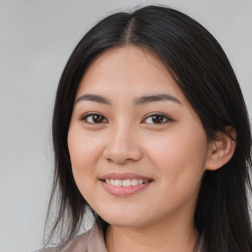 Joyful asian young-adult female with long  brown hair and brown eyes
