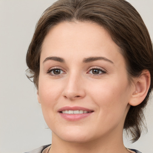 Joyful white young-adult female with medium  brown hair and grey eyes