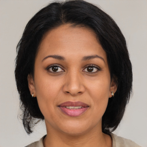 Joyful latino adult female with medium  brown hair and brown eyes