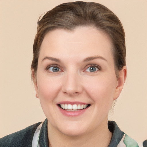 Joyful white young-adult female with medium  brown hair and grey eyes