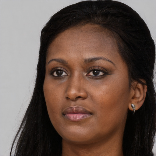 Joyful black young-adult female with long  black hair and brown eyes