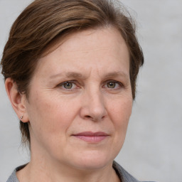 Joyful white adult female with medium  brown hair and grey eyes