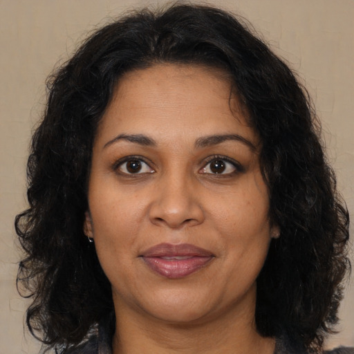 Joyful black adult female with medium  brown hair and brown eyes