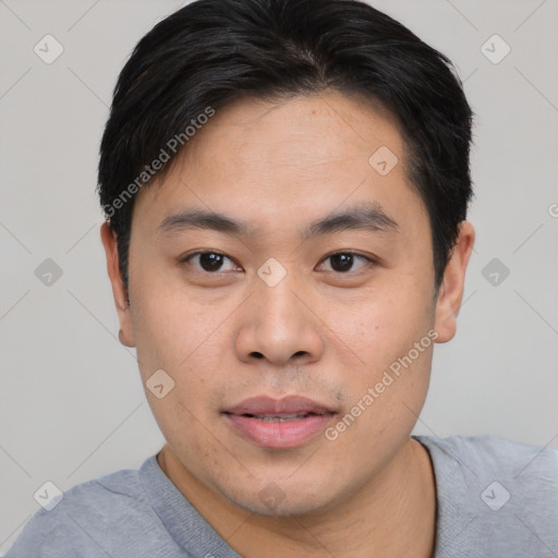 Joyful asian young-adult male with short  black hair and brown eyes