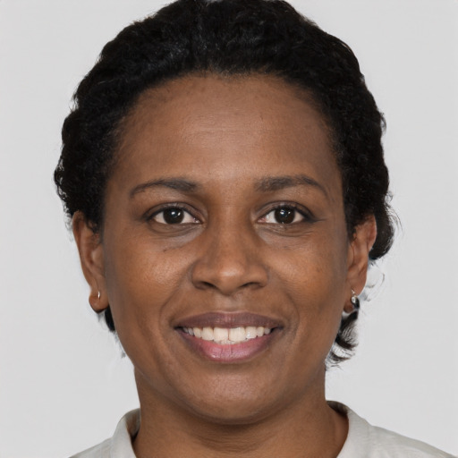 Joyful black adult female with short  black hair and brown eyes