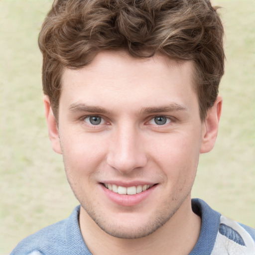 Joyful white young-adult male with short  brown hair and blue eyes