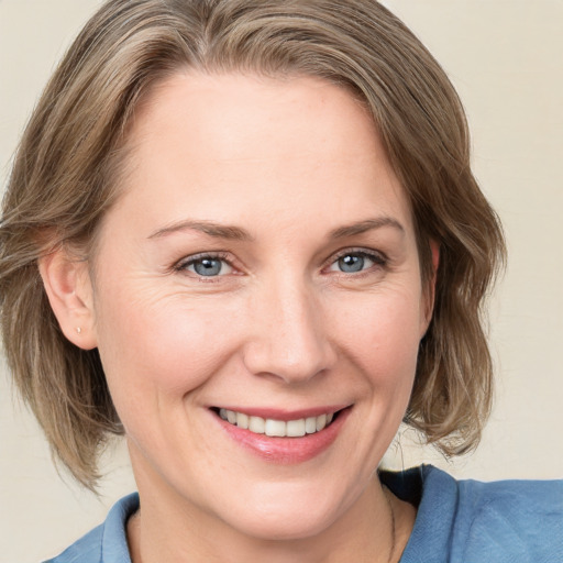 Joyful white young-adult female with medium  brown hair and blue eyes