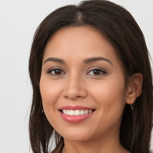 Joyful white young-adult female with long  brown hair and brown eyes