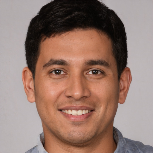 Joyful white young-adult male with short  brown hair and brown eyes