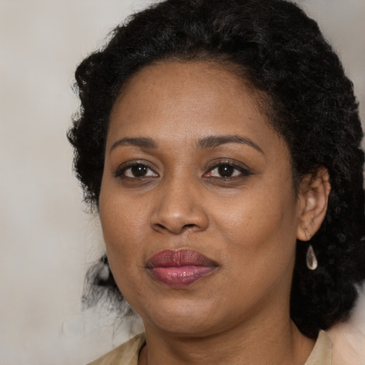 Joyful black adult female with medium  brown hair and brown eyes