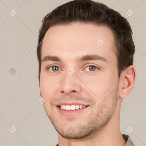 Joyful white young-adult male with short  brown hair and grey eyes