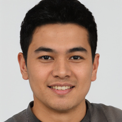 Joyful latino young-adult male with short  black hair and brown eyes