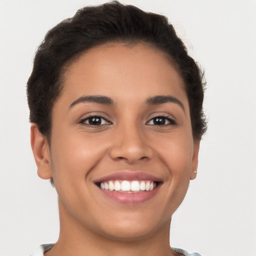 Joyful latino young-adult female with short  brown hair and brown eyes