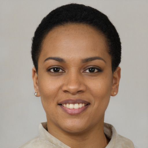 Joyful black young-adult female with short  black hair and brown eyes