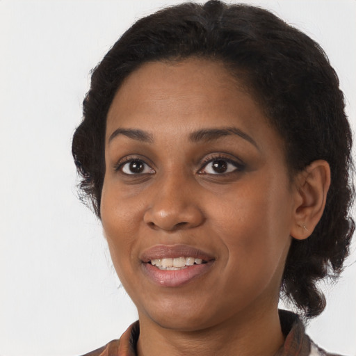 Joyful black adult female with long  brown hair and brown eyes