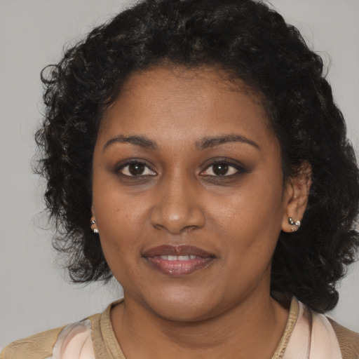 Joyful black young-adult female with medium  brown hair and brown eyes