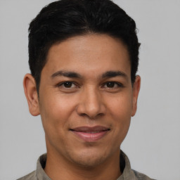 Joyful latino young-adult male with short  brown hair and brown eyes