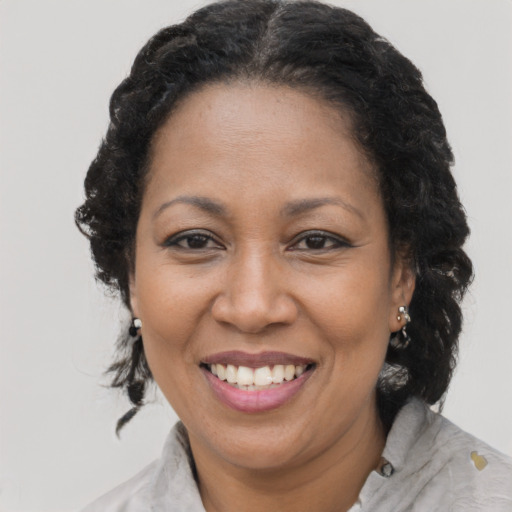 Joyful latino adult female with medium  brown hair and brown eyes