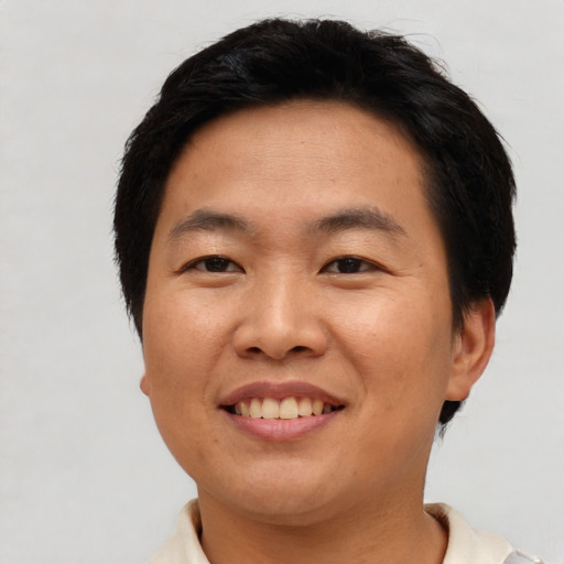 Joyful asian young-adult male with short  black hair and brown eyes