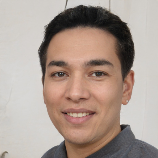 Joyful white young-adult male with short  black hair and brown eyes