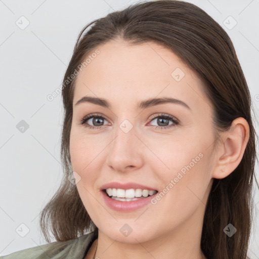 Joyful white young-adult female with long  brown hair and brown eyes