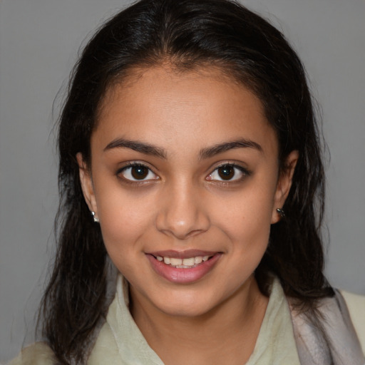 Joyful latino young-adult female with medium  brown hair and brown eyes