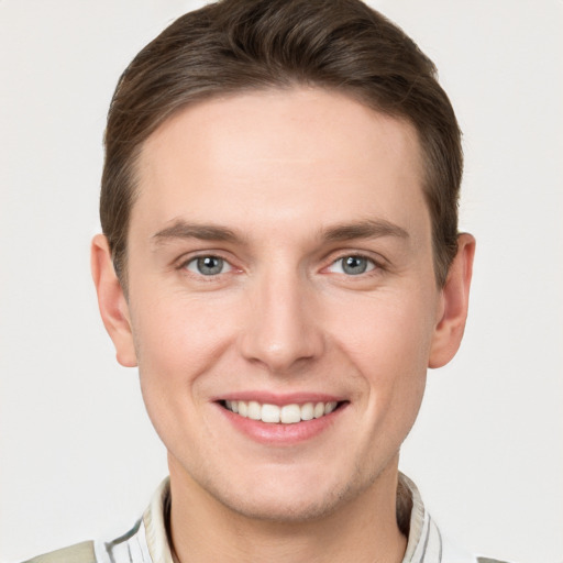 Joyful white young-adult male with short  brown hair and grey eyes