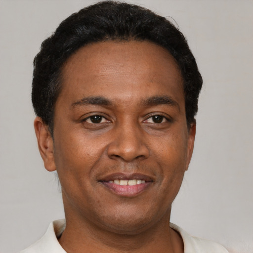 Joyful latino young-adult male with short  brown hair and brown eyes