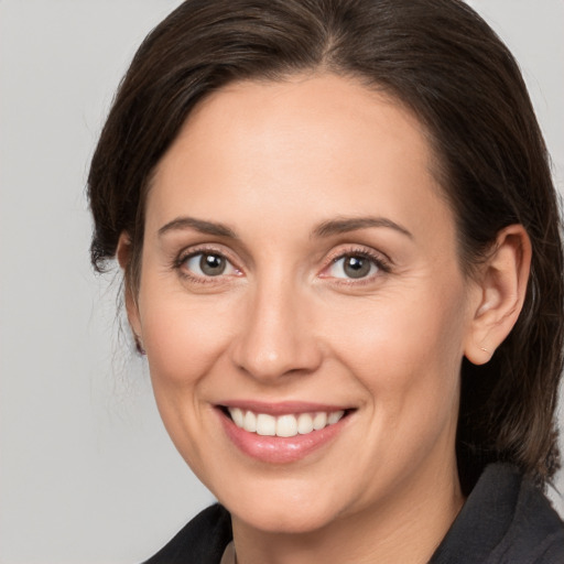 Joyful white adult female with medium  brown hair and brown eyes