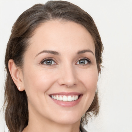 Joyful white young-adult female with medium  brown hair and grey eyes