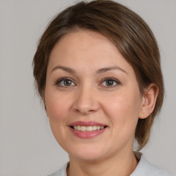 Joyful white young-adult female with medium  brown hair and grey eyes